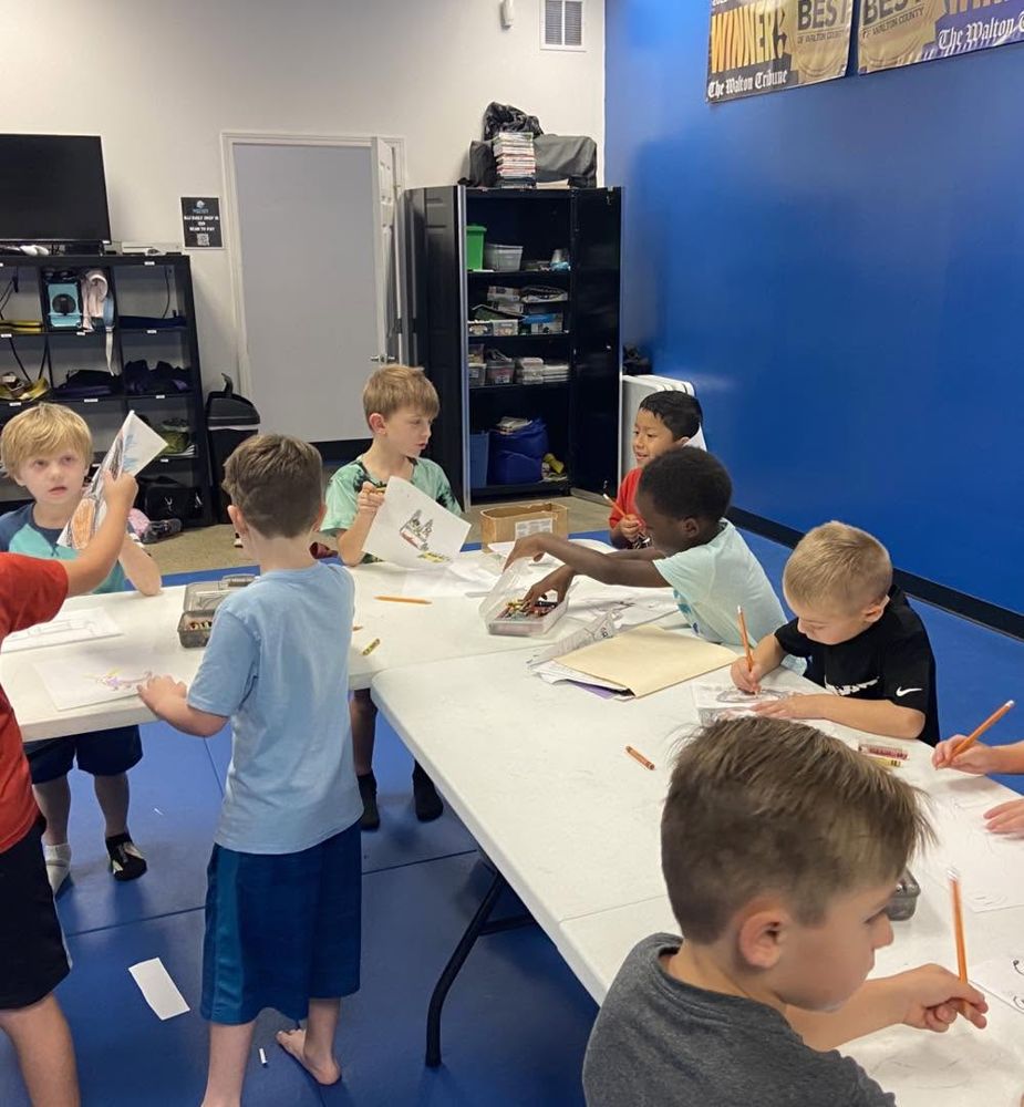 Kids working at long tables with pencils and papers